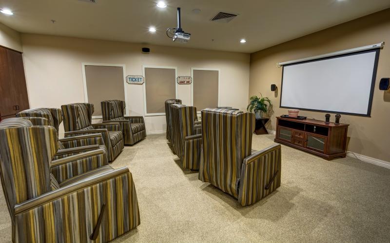 a large room with a large screen and chairs